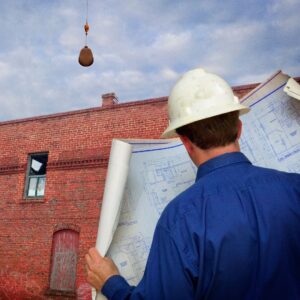 person. holding construction diagram in front of building