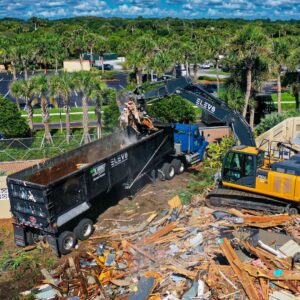 crane moving demolition material into dumpster